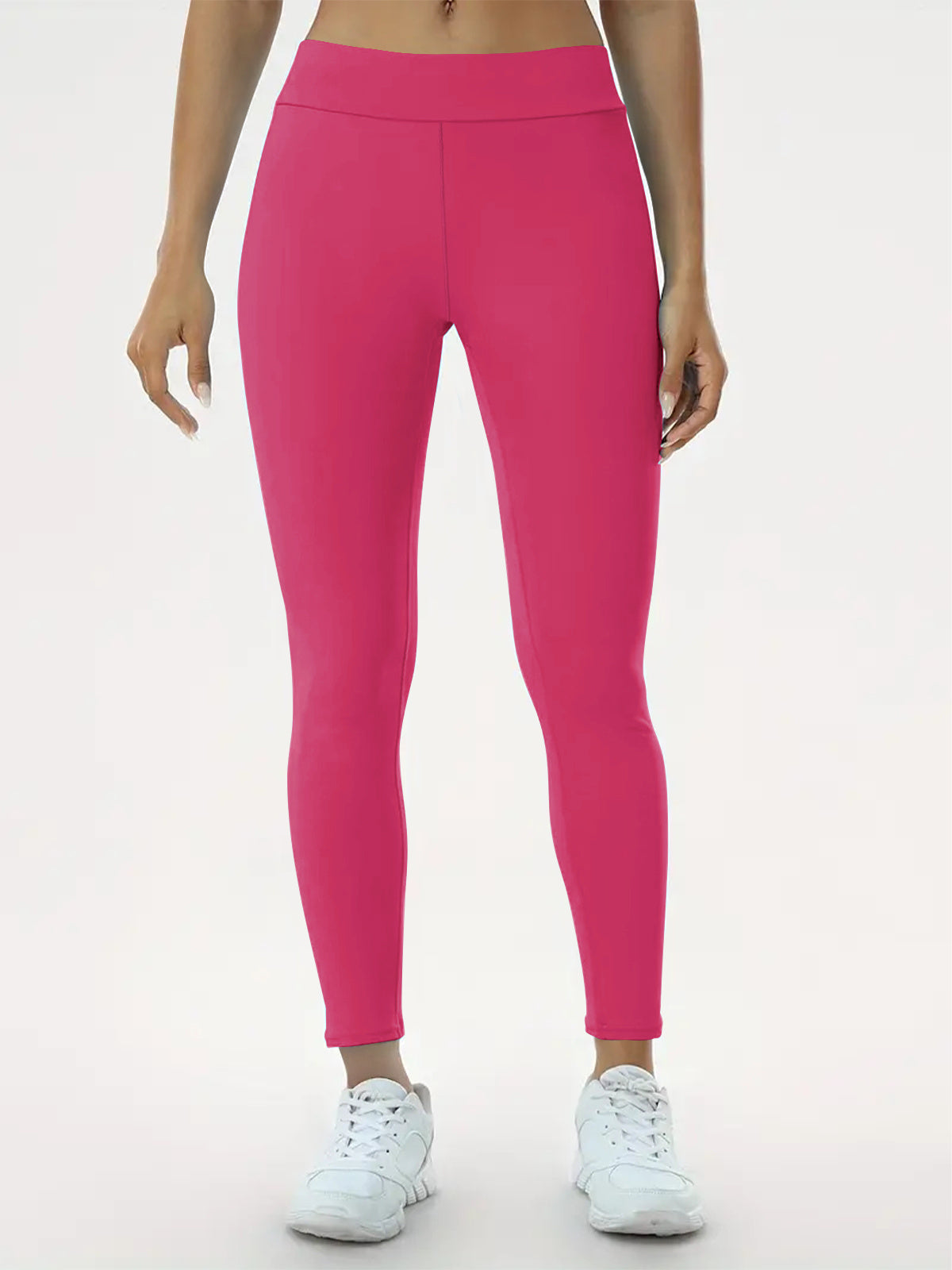 "Woman wearing vibrant pink high-waisted leggings and white sneakers, perfect for yoga, fitness, and everyday activewear."