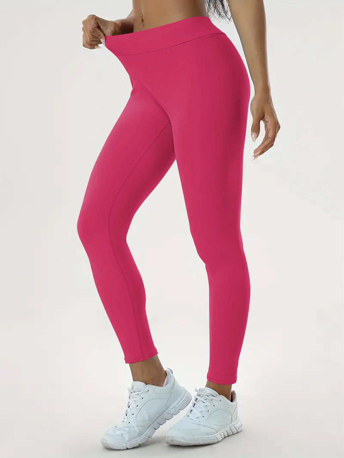 "Person wearing bright pink high-waisted leggings, showcasing stretch and fit, paired with white athletic shoes, ideal for yoga, fitness, and everyday wear."